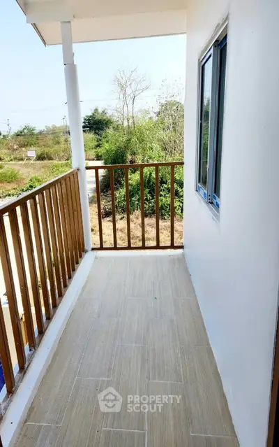 Charming balcony with wooden railing and scenic view, perfect for relaxation and enjoying nature.