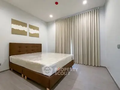 Spacious bedroom with modern decor and large window curtains