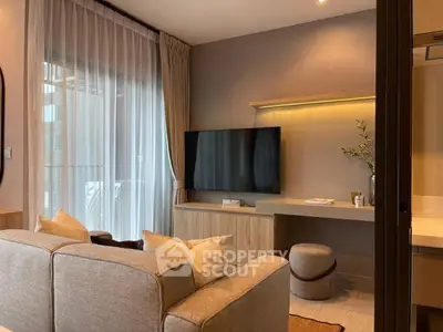 Modern living room with stylish decor and large TV, featuring a cozy sofa and elegant lighting.