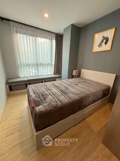 Cozy bedroom with modern decor and large window for natural light