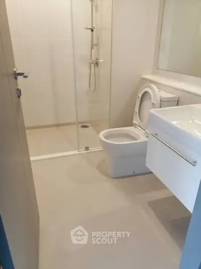 Modern bathroom with glass shower and sleek fixtures in a contemporary home.