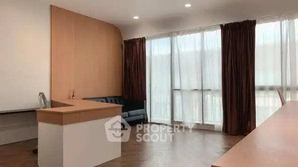 Spacious modern office with large windows and elegant wooden furniture