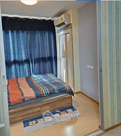 Cozy bedroom with wooden flooring, stylish bed, and air conditioning, perfect for relaxation.
