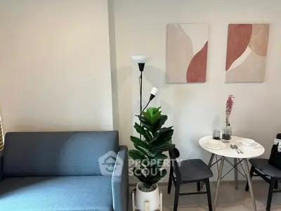 Modern living room with stylish decor, featuring a cozy sofa, elegant dining set, and contemporary artwork.