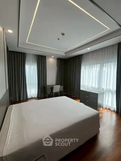Spacious bedroom with modern design and large windows for natural light.