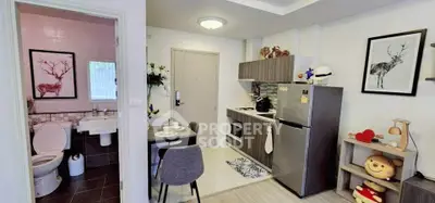 Charming compact apartment with modern kitchen and cozy dining area, adjacent to a stylish bathroom.