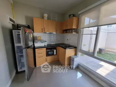 Modern kitchen with sleek appliances and ample natural light, featuring a compact open layout and stylish cabinetry.