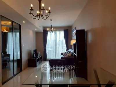 Spacious modern living room with elegant chandeliers and glass dining table, featuring a cozy seating area and large windows.