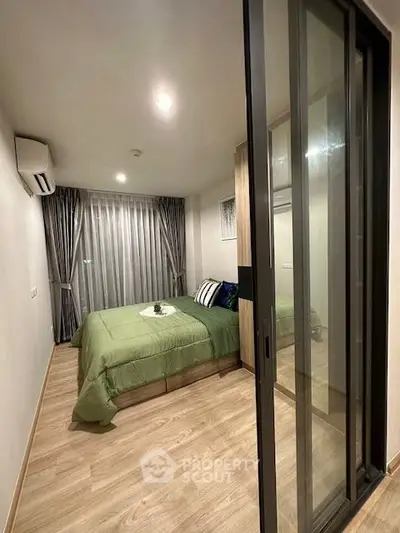 Modern bedroom with sliding glass door and elegant decor in a cozy apartment.