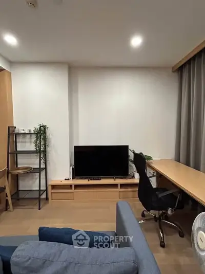 Modern living room with sleek furniture and TV setup, perfect for relaxation and entertainment.