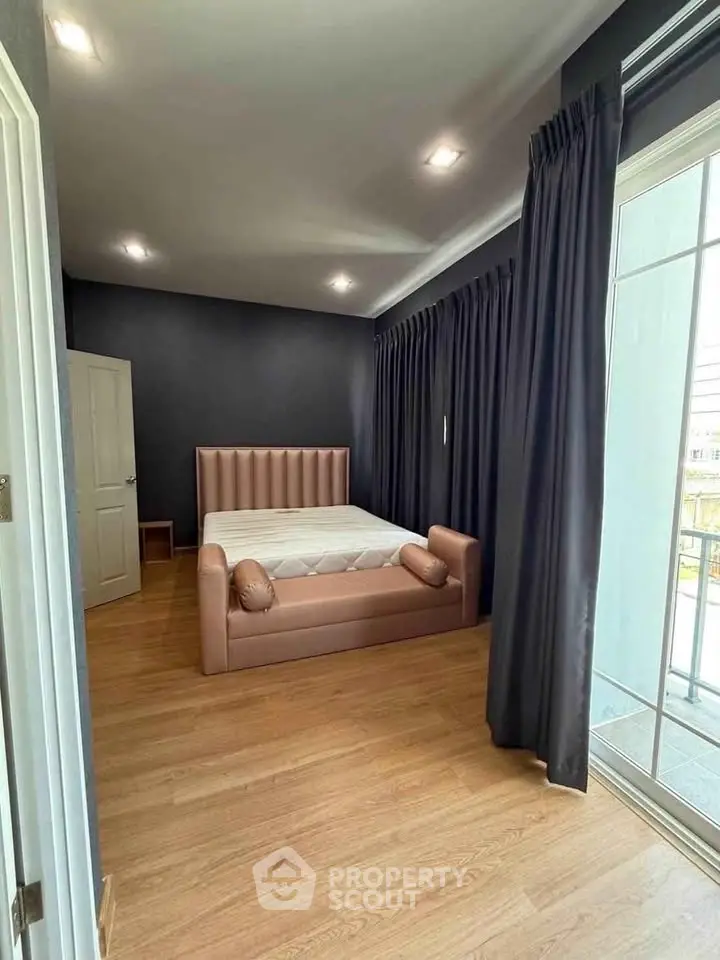 Spacious bedroom with modern decor and large window for natural light