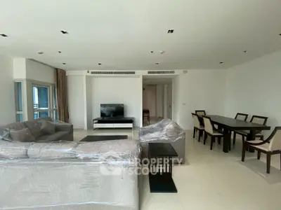 Spacious modern living room with elegant dining area and large windows for natural light.
