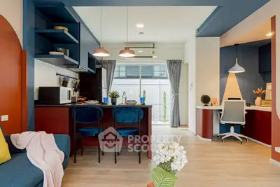 Modern open-plan living room with stylish kitchen and cozy workspace, featuring vibrant colors and contemporary decor.