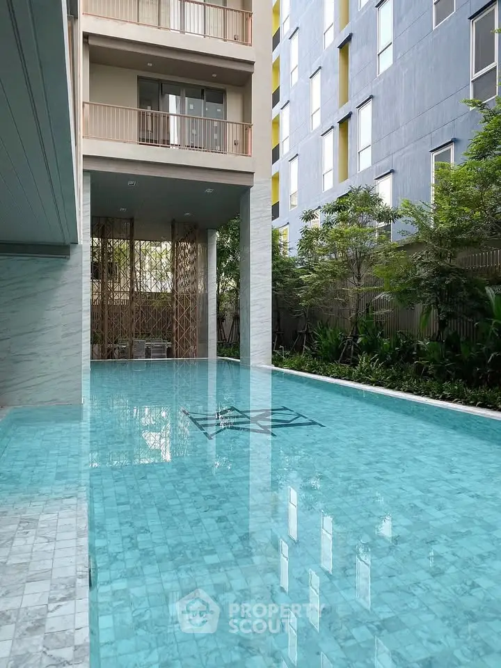Luxurious modern apartment building with a stunning outdoor pool and lush greenery.