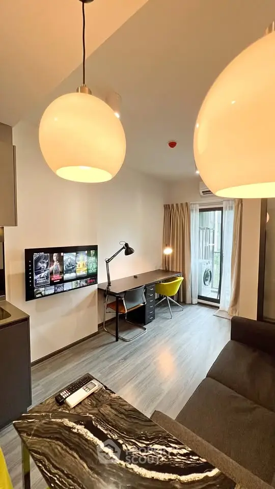 Modern living room with stylish decor and workspace, featuring a sleek TV setup and cozy seating area.