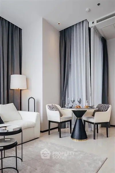 Elegant modern living room with stylish dining area and floor-to-ceiling windows