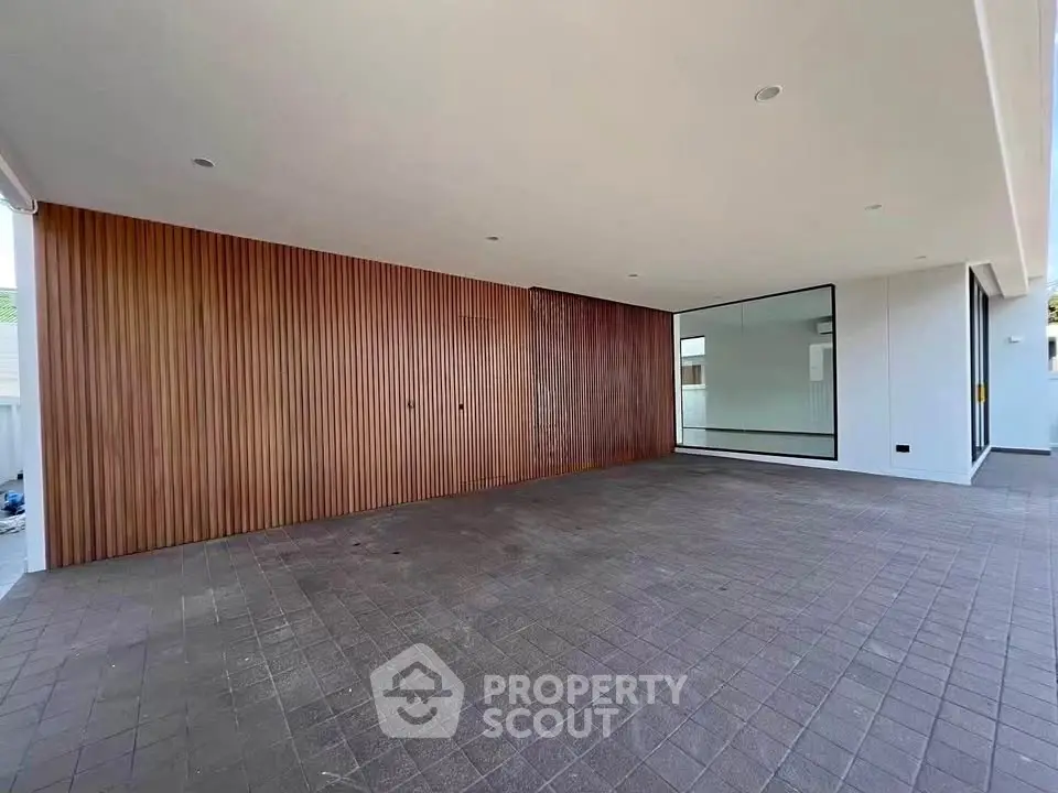 Spacious modern parking area with sleek wooden paneling and large glass windows.