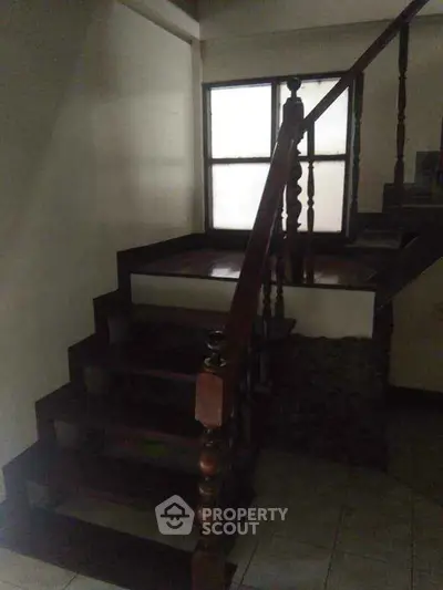 Charming wooden staircase with classic railing in cozy home interior