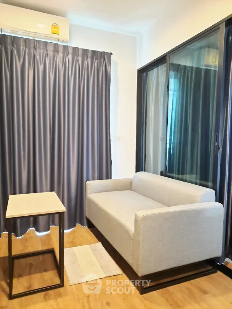 Modern living room with sleek sofa, stylish curtains, and wooden flooring in a cozy apartment.