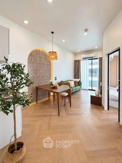 Modern living room with stylish decor and natural light, featuring wooden flooring and elegant furniture.
