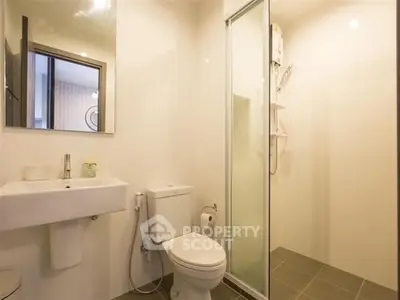 Modern bathroom with sleek fixtures and glass shower enclosure in a contemporary apartment.
