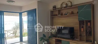 Charming living room with balcony access and stylish wooden entertainment center.