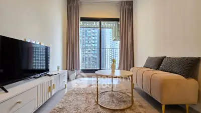 Modern living room with cozy sofa, TV, and city view balcony in high-rise apartment.