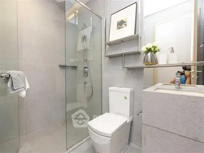 Modern bathroom with sleek design, glass shower, and elegant fixtures.