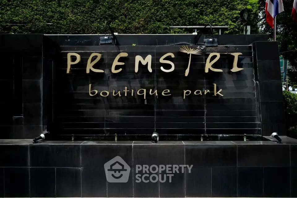 Elegant entrance sign of Premstiri Boutique Park with lush greenery backdrop.