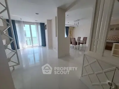 Spacious modern living room with dining area and large windows in a stylish apartment.