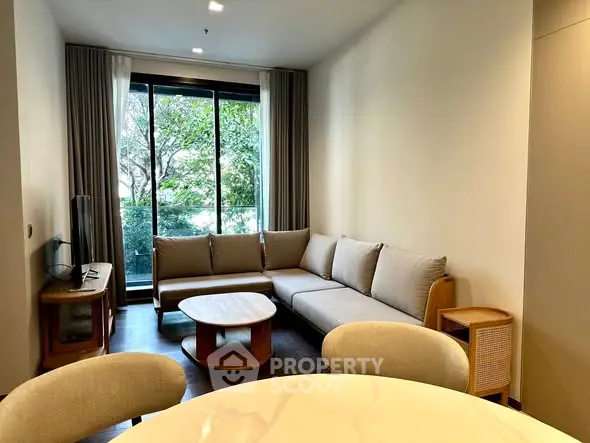 Modern living room with large windows and stylish furniture, offering a cozy and inviting atmosphere.