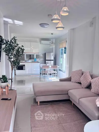 Modern open-plan living room and kitchen with stylish decor and natural light.