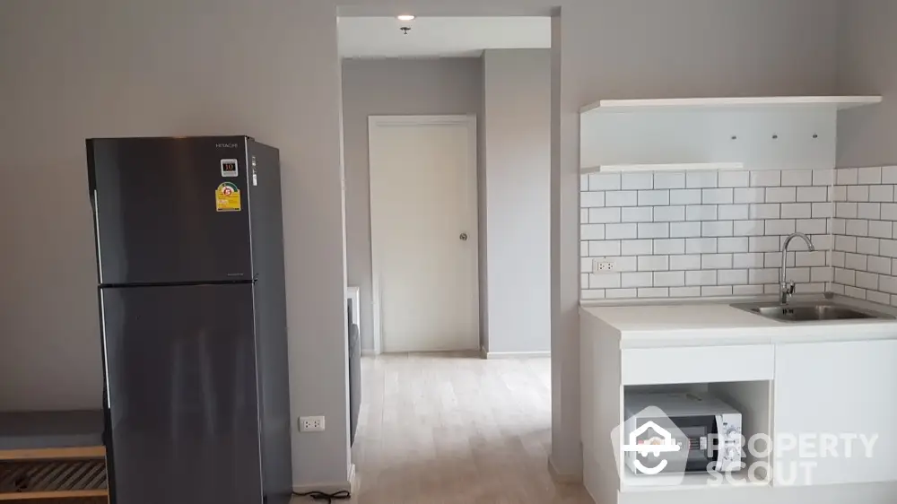 Modern kitchen with sleek black fridge and white subway tile backsplash