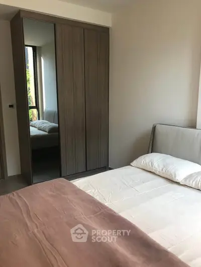 Modern bedroom with sleek wardrobe and cozy bed in a stylish apartment.