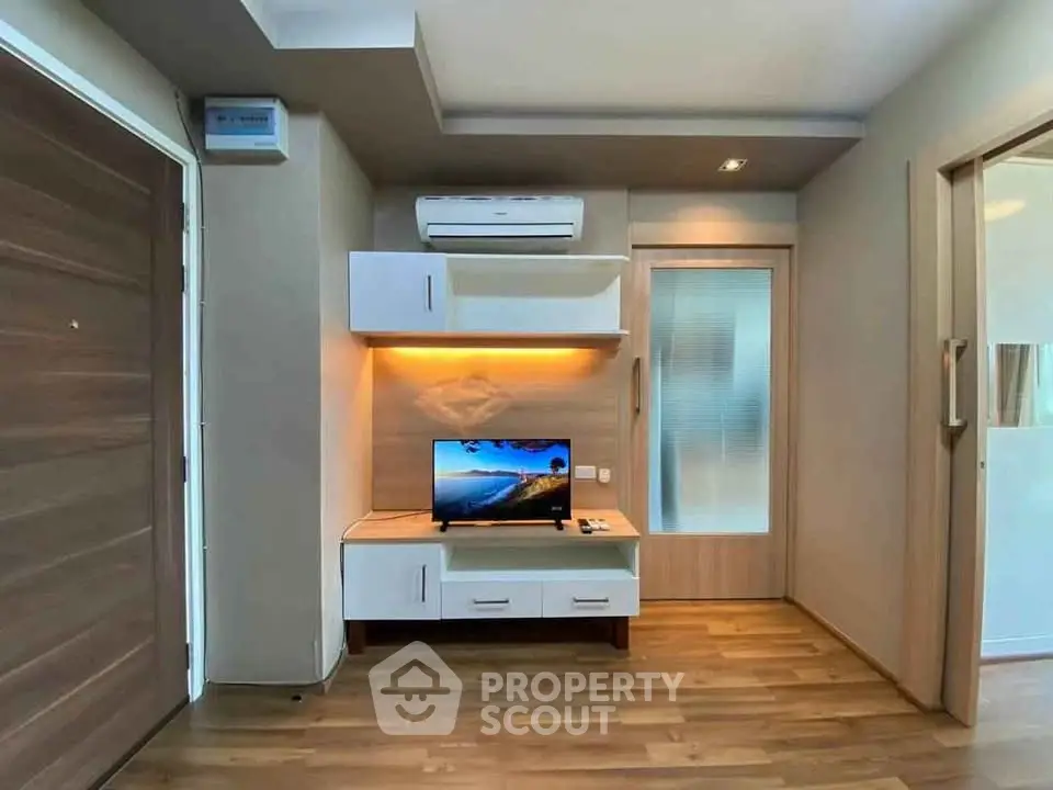Modern living room with sleek wooden flooring and built-in entertainment unit.