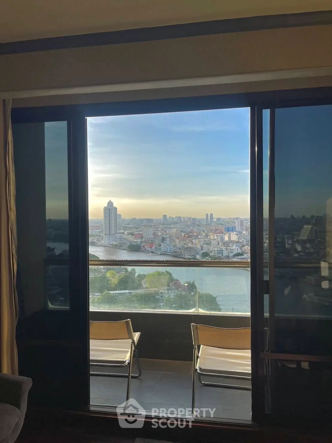 Stunning high-rise balcony view overlooking city skyline and river, perfect for urban living enthusiasts.