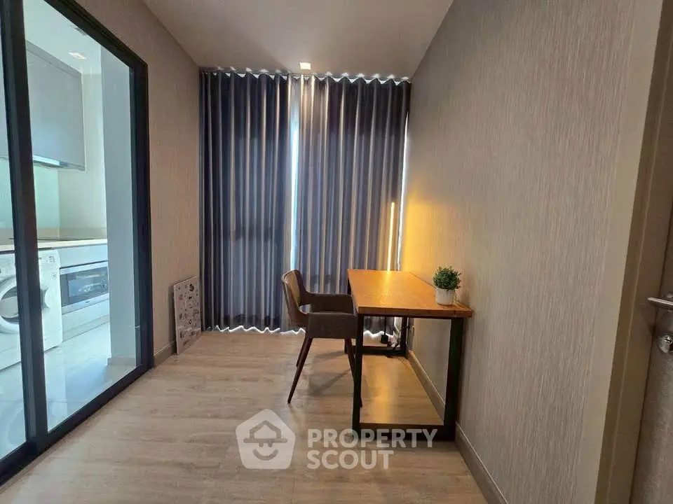 Modern study room with sleek desk and chair, adjacent to a laundry area with washing machine.