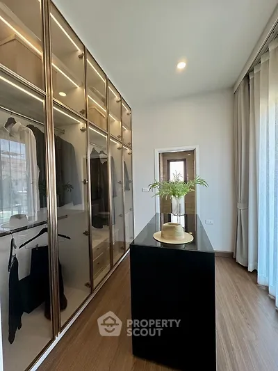 Luxurious walk-in closet with elegant wooden flooring and ample storage space