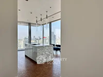 Luxurious modern kitchen with marble island and stunning city view in high-rise apartment.