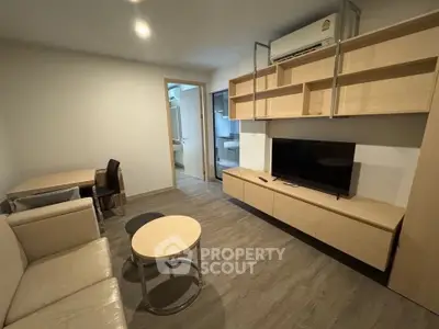 Modern living room with sleek furniture and open layout, featuring a cozy sofa and wall-mounted TV.