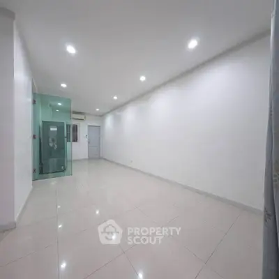 Spacious unfurnished room with modern lighting and tiled flooring, ideal for customization.