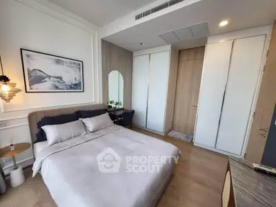 Modern bedroom with stylish decor and ample natural light, featuring a cozy bed and elegant furnishings.