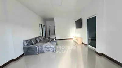 Spacious modern living room with sleek furniture and wall-mounted TV