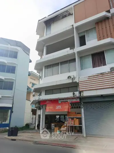 Commercial building exterior with street view, showcasing potential retail space in a bustling urban area.