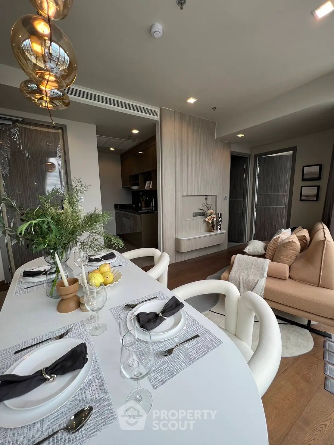 Stylish modern living room with open kitchen and elegant dining setup.