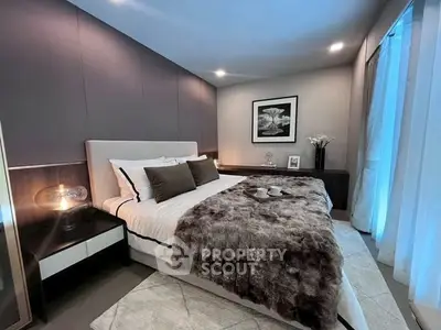 Luxurious bedroom with elegant decor and plush bedding in modern apartment.