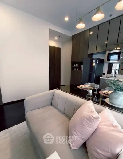 Modern living room with sleek kitchen, cozy sofa, and elegant decor in a stylish apartment.