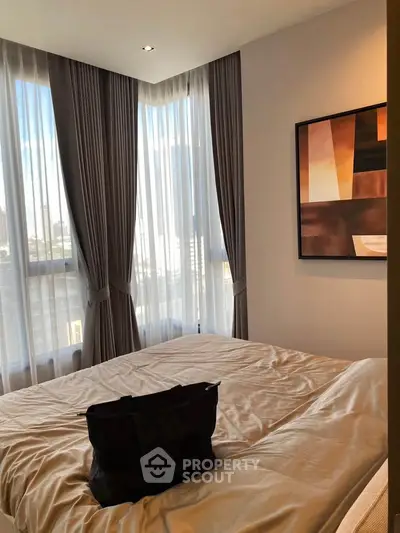 Modern bedroom with large windows and stylish decor in a high-rise apartment.