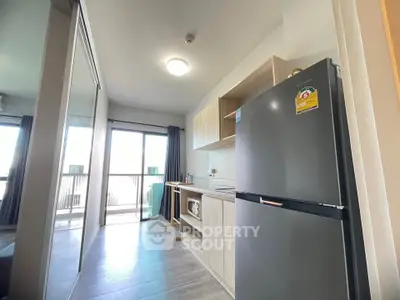 Modern kitchen with sleek appliances and balcony view in urban apartment