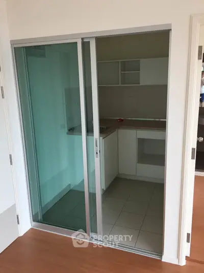Compact kitchen with sliding glass doors and modern cabinetry